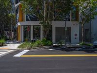 a street with lots of trees in front of it and two traffic lights on either side of the road