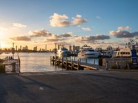 an image of a sunset setting on the pier with boats and yachts in the water