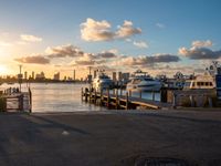 an image of a sunset setting on the pier with boats and yachts in the water