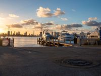 an image of a sunset setting on the pier with boats and yachts in the water