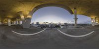 the view from inside a concrete tunnel looking into the city, with the sky behind