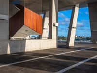 two large concrete pillars with brown and red panels on them at a city parking lot