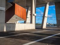 two large concrete pillars with brown and red panels on them at a city parking lot