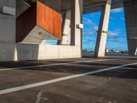 two large concrete pillars with brown and red panels on them at a city parking lot