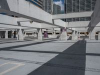 a large concrete garage has many parking meters on it's side with tall buildings