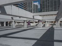 a large concrete garage has many parking meters on it's side with tall buildings