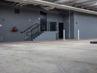 an empty warehouse room with stairs and a sign on the wall above it and stairs on the wall below