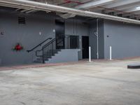 an empty warehouse room with stairs and a sign on the wall above it and stairs on the wall below