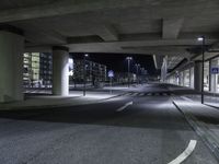 a long shot of an empty street underpass at night time with no light on