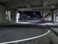 a long shot of an empty street underpass at night time with no light on