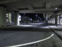 a long shot of an empty street underpass at night time with no light on