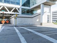 a building that has a road blocked off by a yellow traffic sign on the side walk