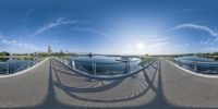 a view of the lake and bridge from a fish eye lens pano of an elevated walkway in front of water