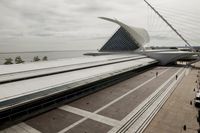 the train station has many lines on each side of it and a very long white structure in front of the water