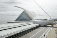 the train station has many lines on each side of it and a very long white structure in front of the water