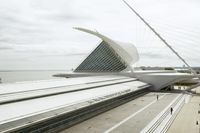 the train station has many lines on each side of it and a very long white structure in front of the water