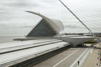 the train station has many lines on each side of it and a very long white structure in front of the water