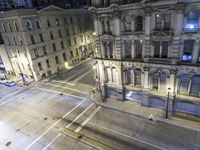 an aerial view of a street and cars driving down the road at night in the city