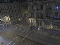 an aerial view of a street and cars driving down the road at night in the city