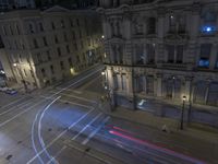 an aerial view of a street and cars driving down the road at night in the city