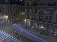 an aerial view of a street and cars driving down the road at night in the city