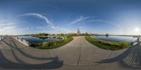 fish eye view of the landscape and water in the park, taken from a skateboard park