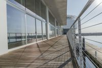 the long walkway over a river through a pier to water with a boat and light