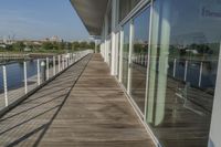 the long walkway over a river through a pier to water with a boat and light