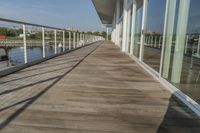 the long walkway over a river through a pier to water with a boat and light