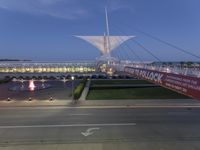 a view of a bridge and fountain at dusk from a tall building near a street