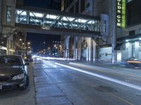 cars are parked on the sidewalk by a curb in the city at night with a traffic light on