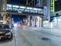cars are parked on the sidewalk by a curb in the city at night with a traffic light on