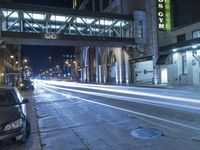 cars are parked on the sidewalk by a curb in the city at night with a traffic light on