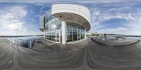 a panorama fish - eye view of a building in the background with wooden flooring