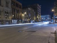 a night time view of city streets with buildings and a car driving at the same lane