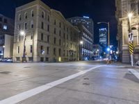 a night time view of city streets with buildings and a car driving at the same lane