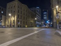 a night time view of city streets with buildings and a car driving at the same lane