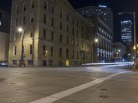 a night time view of city streets with buildings and a car driving at the same lane