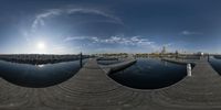 fisheye lens with photo of city and water in the background and dock area at dusk