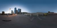 a cityscape with a large building in the background at dusk, as well as a skate park