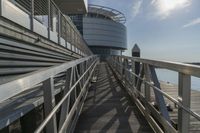 metal railing next to pier near large building by water's edge area on sunny day