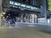 a street with lights and parking meters, in the background is tall buildings and street lights,
