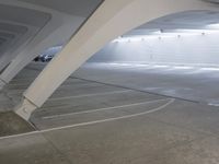 a parking lot has a car inside of it in the middle of the room with a concrete structure on the corner