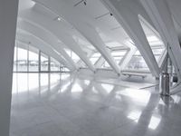 empty white lobby with white marble floor and ceiling tiles, as well as three benches and glass windows