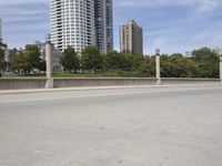 a person on a skateboard crossing an overpass on a street next to some high rise buildings