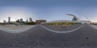 an open walkway and buildings with the skyline in the background behind them seen from the reflection of a fish eye lens