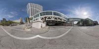 a fisheye lens image shows a city in the background with buildings and pedestrians crossing