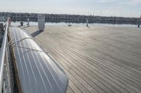 a long bench on top of a pier next to a body of water filled with boats