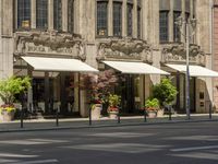 a building that looks great with beautiful flowers on the street front door is surrounded by many decorative planters