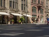 a building that looks great with beautiful flowers on the street front door is surrounded by many decorative planters